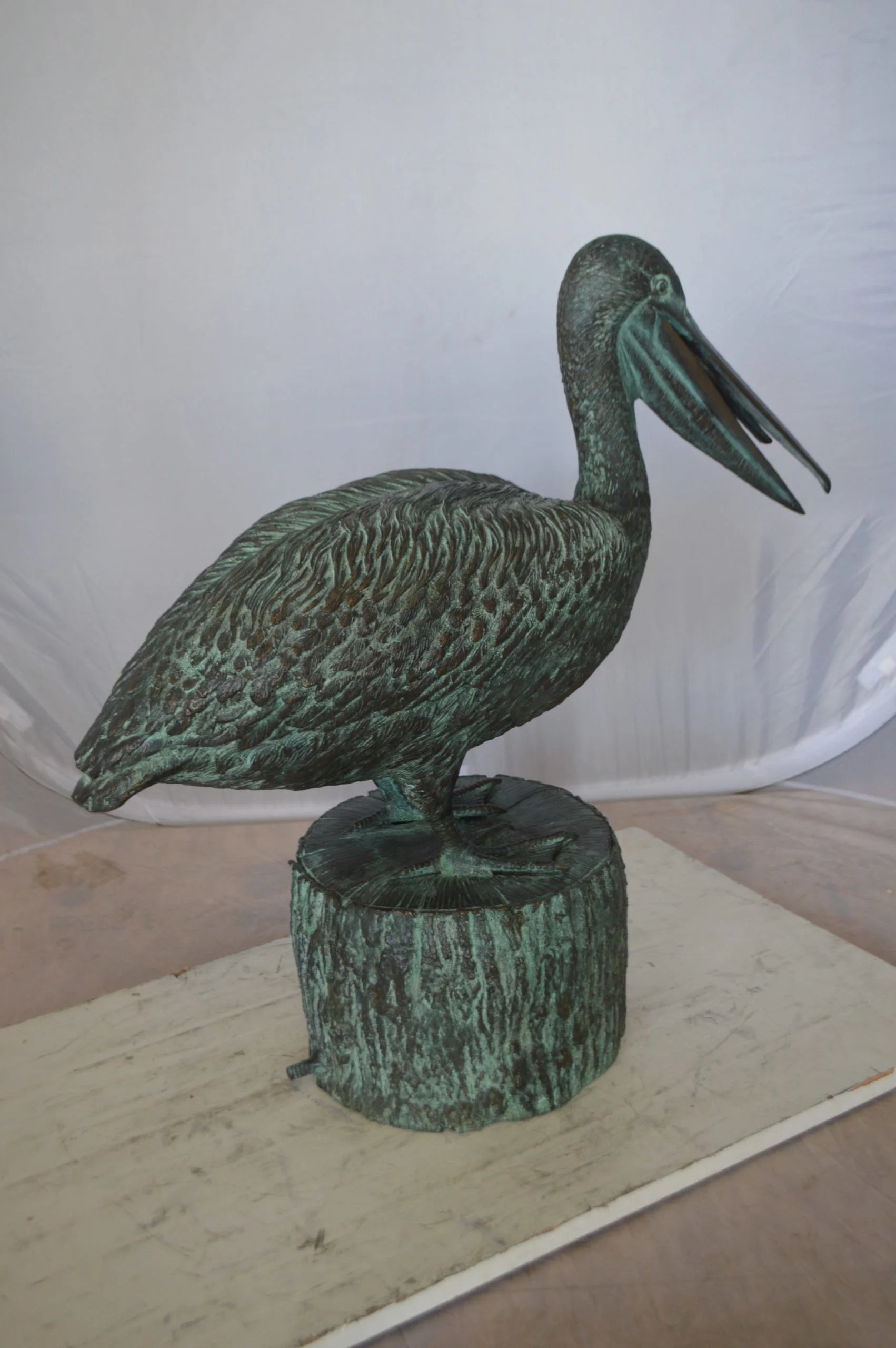 Nifao Pelican on a Tree Stump fountain bronze statue - Size: 30"L x 16"W x 46"H.